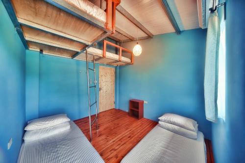 恆春的住宿－藍洞潛水Blue Hole Dive Center，蓝色墙壁客房的两张床