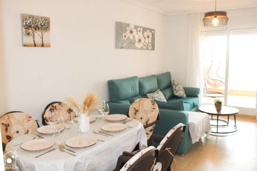 a living room with a table and a green couch at Fantástico Ático Chill Out con Vistas a Mar de Cristal in Mar de Cristal
