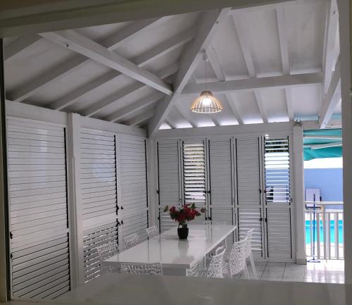 a dining room with a table with flowers on it at Villa Serenity in Saint-François