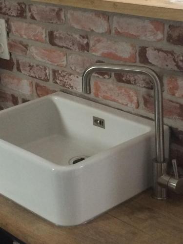 a white sink in front of a brick wall at De Weegbrug in IJzendijke