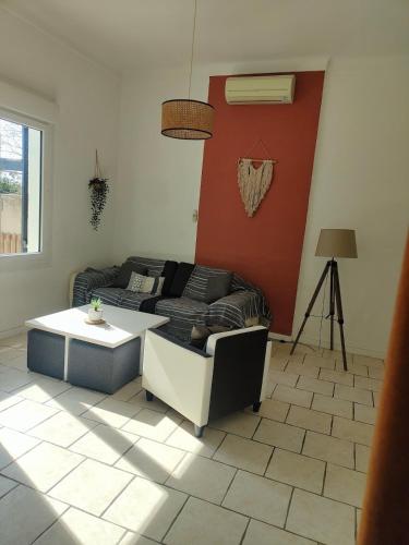 a living room with a couch and a table at Family Home & Fun in LʼIsle-sur-la-Sorgue