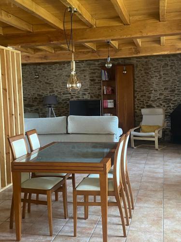 a table and chairs in a living room with a couch at VUT Rural 2 in Arzúa