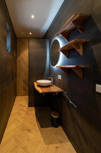 a bathroom with a sink and a wooden wall at Maria's hoeve Abcoude huisje 2 dichtbij Amsterdam in Abcoude