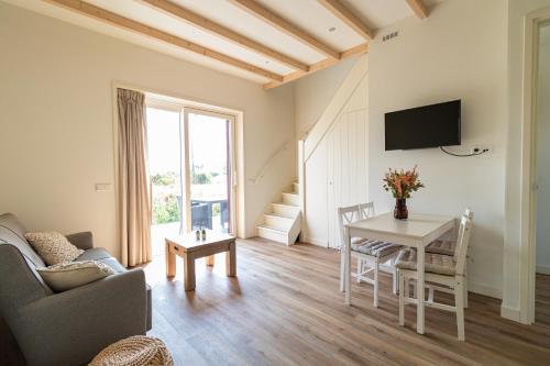 a living room with a table and a tv at Maria's hoeve Abcoude huisje 2 dichtbij Amsterdam in Abcoude