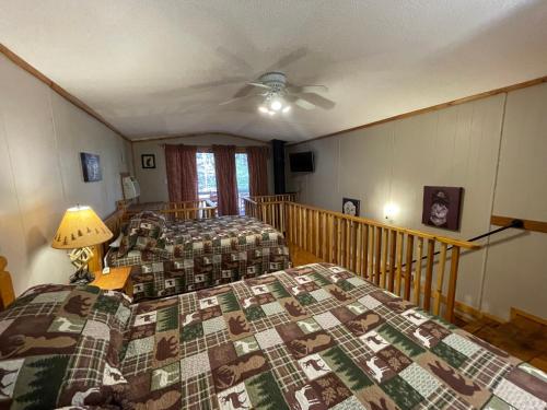 a bedroom with two beds and a ceiling fan at Amazing Cabin fireplace and stream #11 in Helen
