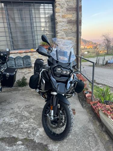 a black motorcycle parked in front of a building at La corte dei celti -1 in San Benedetto Del Querceto