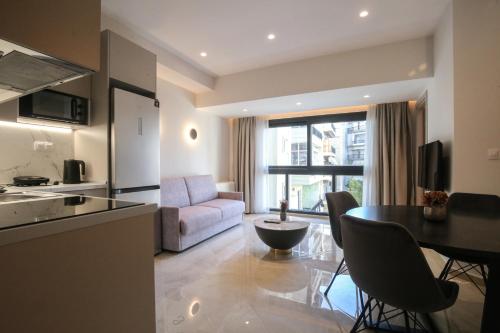 a kitchen and living room with a table and a couch at VILLA 8 By ProLiving Hospitality in Thessaloniki
