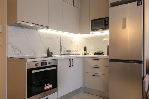 a kitchen with white cabinets and a refrigerator at VILLA 8 By ProLiving Hospitality in Thessaloniki