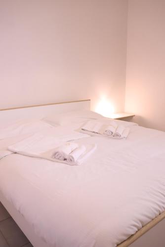 a white bed with two towels on it at La Torre guest house in Acireale