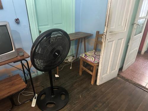 a fan in a room with a desk and a television at Chandra Multiespacio in Gualeguaychú