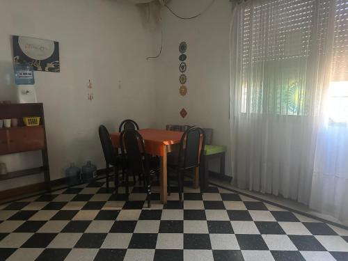 a dining room with a table and chairs on a checkered floor at Chandra Multiespacio in Gualeguaychú