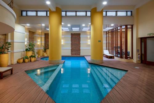 ボゴタにあるHotel De La Operaの柱のあるロビーのスイミングプール