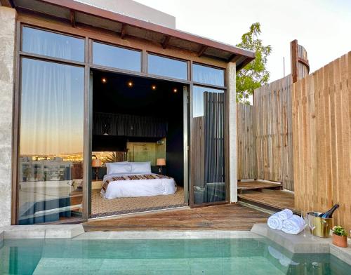 a bedroom with a bed on a balcony with a pool at 2 Lux Suites in Oasis Compound at The Oliver Cabo in Cabo San Lucas
