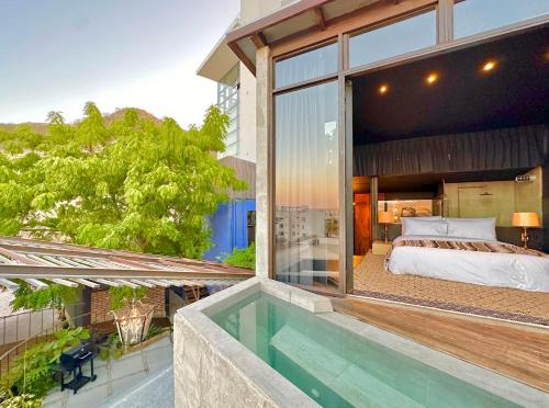 a bedroom with a bed and a swimming pool at 2 Lux Suites in Oasis Compound at The Oliver Cabo in Cabo San Lucas
