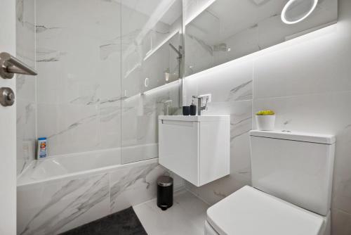 a white bathroom with a toilet and a bath tub at Schwarzwald Moment am Monbachtal in Bad Liebenzell