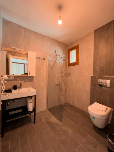a bathroom with a shower and a toilet and a sink at Alice Tatil Evi OTEL in Selimiye