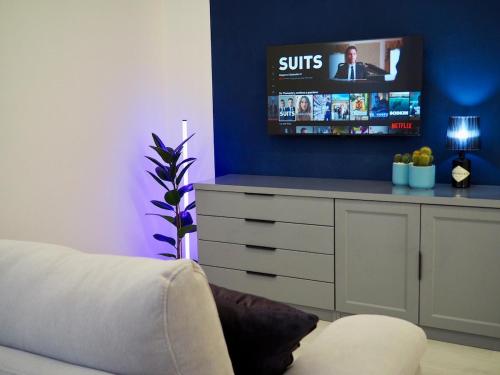 a living room with a tv on a blue wall at Tamerici Salmastre-Montesilvano in Montesilvano