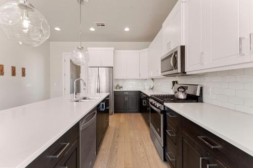 a kitchen with white cabinets and black appliances at Villa #01 at Bloomington Country Club condo in St. George