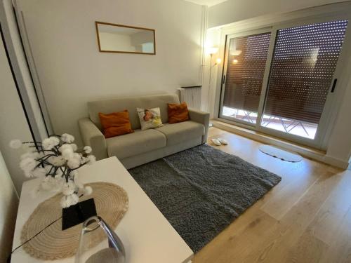 un salon avec un canapé et une grande fenêtre dans l'établissement Ecrin de fleurs, à Gentilly