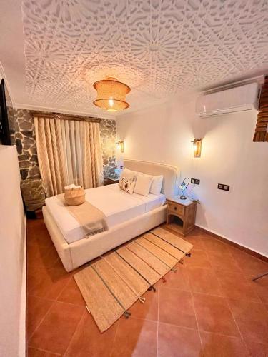 a bedroom with a large white bed in a room at Riad abi khancha in Chefchaouene