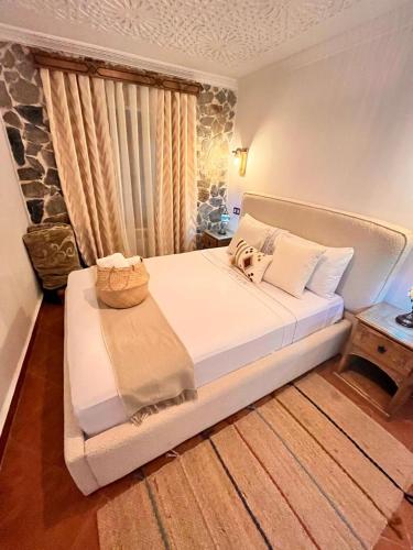 a bedroom with a white bed with a basket on it at Riad abi khancha in Chefchaouene