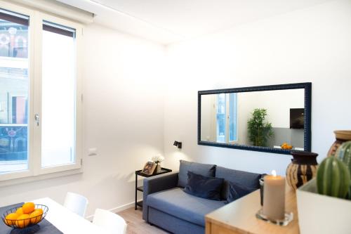 a living room with a blue couch and a mirror at Suite Apartments - Corso51 in Rimini