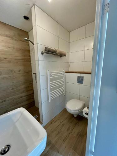 a bathroom with a white toilet and a sink at Kings View Cottage, nu met nieuwe grote BBQ in Warmenhuizen