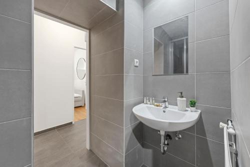 a bathroom with a sink and a mirror at K22 Smart Rooms in Vienna