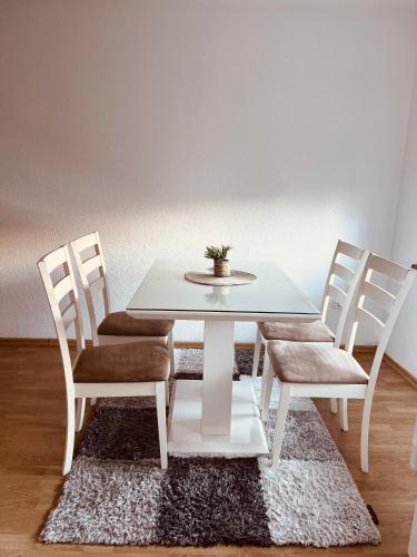 a white table and chairs with a potted plant on it at Apartman 007 in Jajce