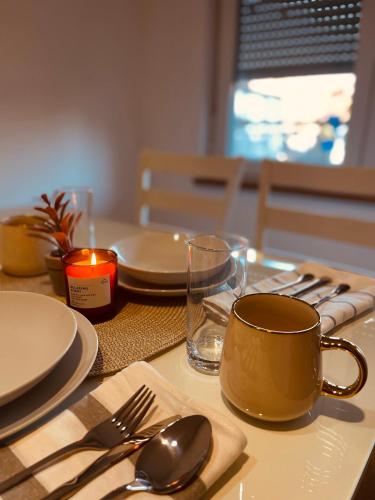 a table with plates and utensils and a coffee cup at Apartman 007 in Jajce