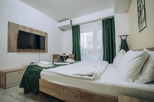 a bedroom with a large bed with a tv on the wall at Darki Apartments 2 - Very Central Stay With Free Parking in Ohrid