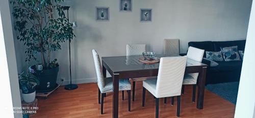 a dining room table with white chairs in a room at Entre Ville & Nature-Sejour idéal a Massy in Massy