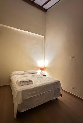 a bedroom with a bed with a lamp on it at Nomad House in Kandana