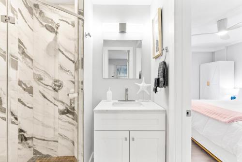 a white bathroom with a sink and a shower at Beach Rd, 300ft to Beach Access & 500ft to Siesta Key Village, 1bdr in Siesta Key