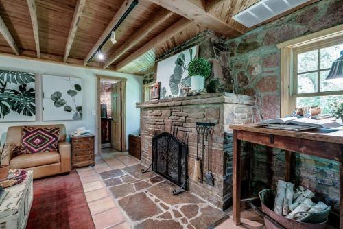 a living room with a stone fireplace in a house at The Gate House- Autumn Retreat In Edmond, Ok in Edmond