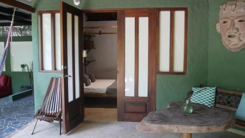 a room with a door and a room with a bed at Pachamama Tropical Garden Lodge in Carmen