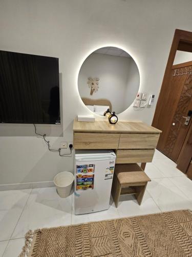 a bathroom with a sink and a desk with a mirror at سكينة المدينة 101 in Al Madinah