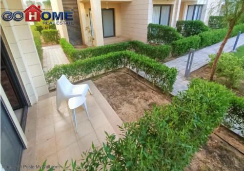 a white chair sitting on a patio in front of a building at Cozy Studio 1BR G Cribs b19-g7 El-Gouna Shared Heatd Pool in El Gouna