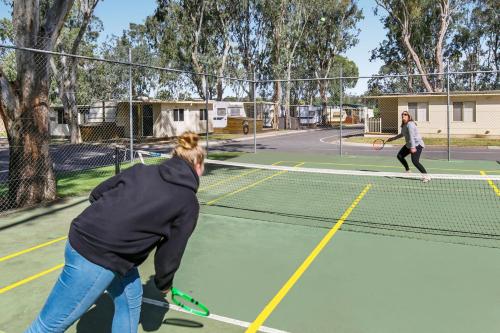 two people playing tennis on a tennis court at BIG4 Mannum Holiday Park in Mannum