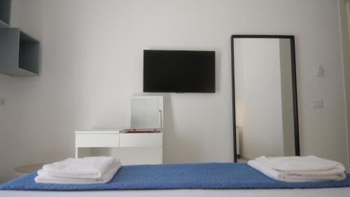 a bedroom with a bed with a tv on the wall at Il Vicoletto B&B in Cirò Marina