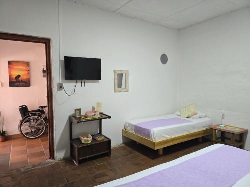 a bedroom with a bed and a tv on the wall at La Casona Espacio Bonito in Zapatoca
