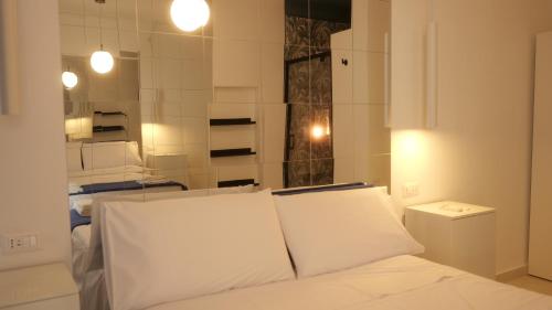 a white bed with white pillows in a room at Il Vicoletto B&B in Cirò Marina