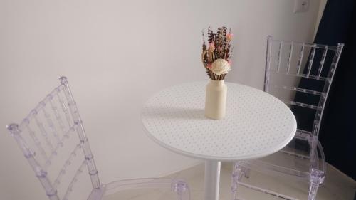 a white table with a vase on it next to two chairs at Il Vicoletto B&B in Cirò Marina