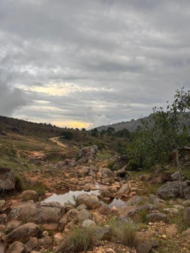 a rocky field with a dirt road and a river at La Casona Espacio Bonito in Zapatoca