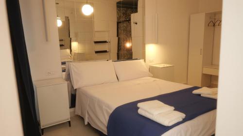 a bedroom with a white bed with towels on it at Il Vicoletto B&B in Cirò Marina