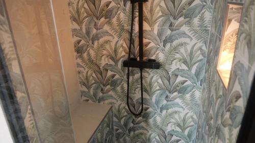 a shower in a bathroom with a wall covered in wallpaper at Il Vicoletto B&B in Cirò Marina