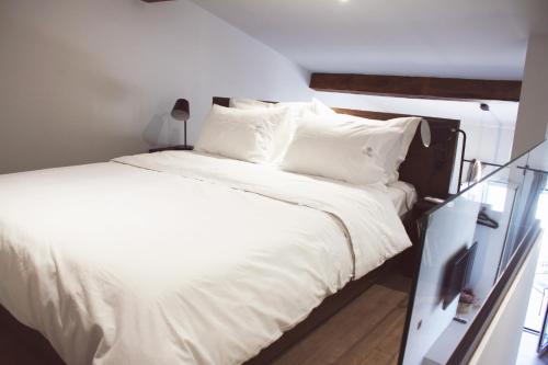 a bedroom with a bed with white sheets and pillows at Art Studios Gialova Navarino in Gialova