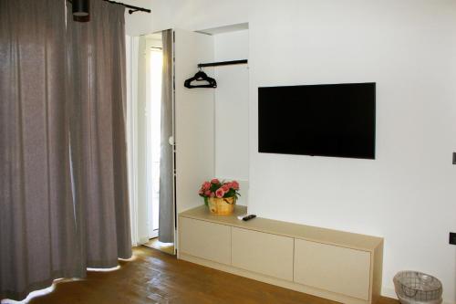 a living room with a tv on a white wall at Art Studios Gialova Navarino in Gialova