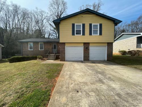 a yellow house with two garage doors at Family Retreat Get Away in Decatur