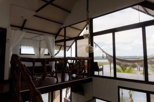 a room with large windows and a hammock at Cabaña Jaguar in Flores